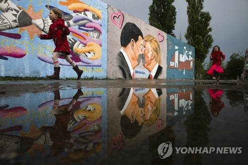 독일 베를린 한 공원 담장에 그려진 도널드 트럼프 미국 대통령(가운데 오른쪽)과 시진핑 중국 국가주석이 마스크를 낀 채 입맞춤을 하고 있다.[사진=연합뉴스]