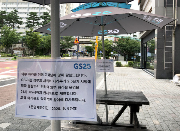 GS25 외부 파라솔에 21시~05시 미운영안내문이 부착되어 있다.