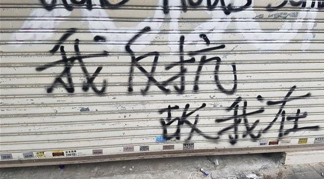 19일 홍콩 침사추이의 한 점포에 시위대가 쓴 '나는 저항한다. 고로 나는 존재한다'라는 문구가 적혀 있다.