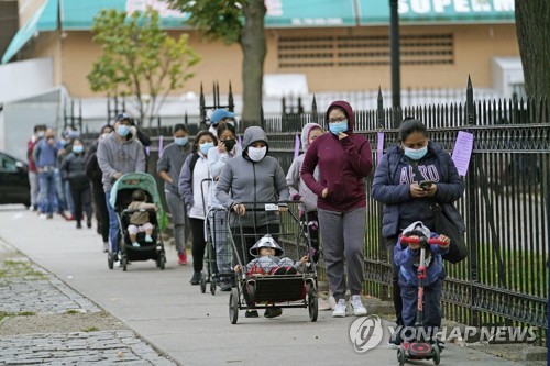 지난 27일(현지시간) 미국 뉴욕 퀸즈 인근에서 현지 주민들이 기부 식량을 받기 위해 줄지어 서 있다.[사진=AP·연합뉴스]