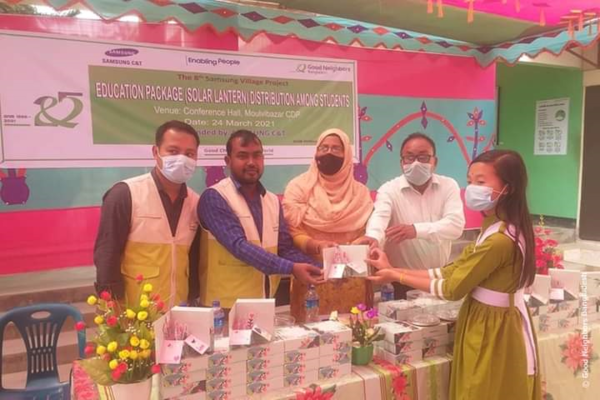 지난 24일(현지시간) 방글라데시 굿네이버스 관계자가 삼성물산이 기부한 태양광 손전등을 학생에게 나눠주고 있다. /사진=굿네이버스