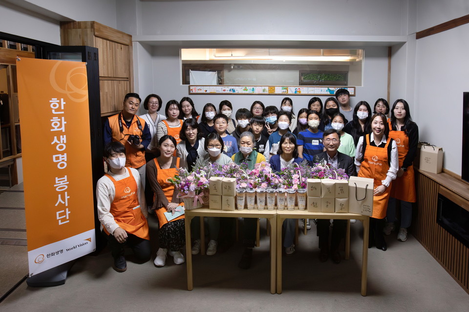 한화생명 임직원 봉사단과 민들레학교지역아동센터 아동, 선생님들이 '카네이션 꽃 바구니 선물 만들기'를 진행한 후 기념촬영을 하고 있다. / 사진=한화생명
