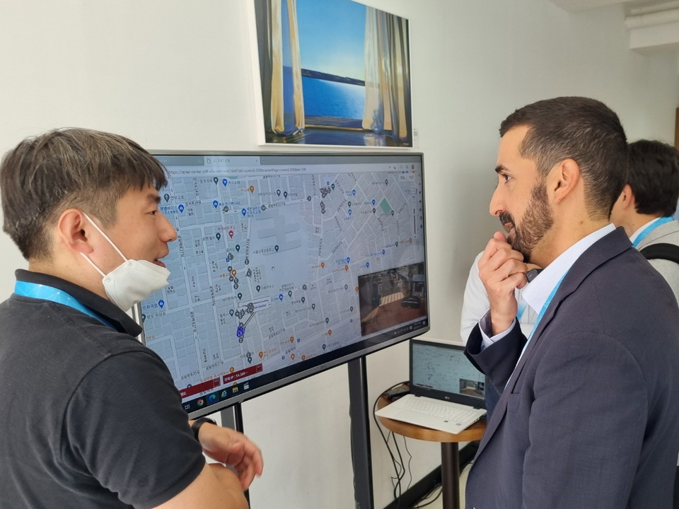 LG전자 관계자(왼쪽)가 글로벌 차량통신 연합체 5GAA(5G Automotive Association) 관계자에게 자율주행 기술 기반 교통안전 솔루션 소프트(Soft) V2X(차량·사물간 통신) 앱을 소개하고 있다. / 사진= LG전자