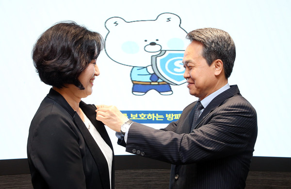 (오른쪽)진옥동 신한금융그룹 회장이 박현주 신한금융지주 부사장에게 소비자보호 뱃지를 달아주고 있다 / 사진=신한금융그룹