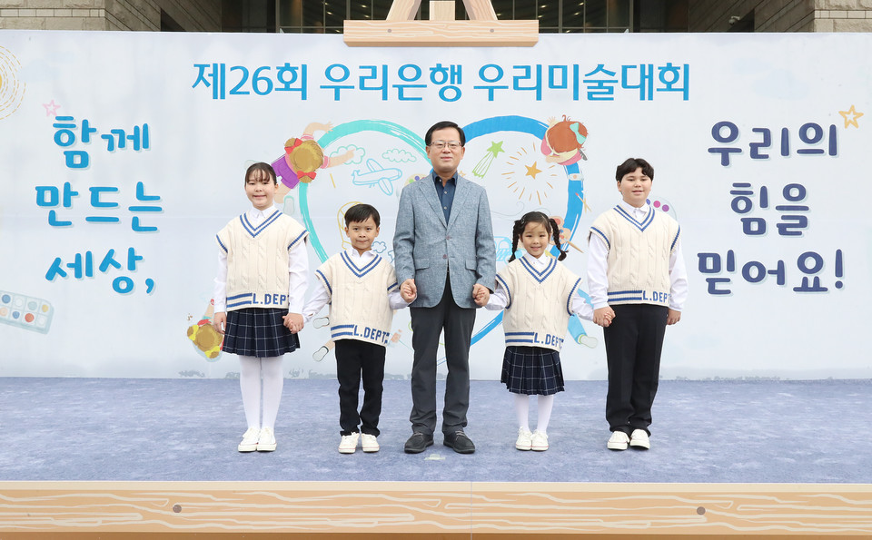 우리은행 조병규 은행장(가운데)이 지난 14일 용산 전쟁기념관에서 열린 '제26회 우리은행 우리미술대회' 축하공연 및 그림주제 발표에 함께 참여한 우리다문화어린이합창단 단원들과 기념사진을 촬영하고 있다. / 사진=우리은행