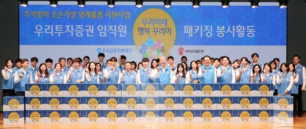 지난 9일 우리금융그룹 임종룡 회장(앞줄 오른쪽에서 아홉번째), 우리투자증권 남기천 대표이사(앞줄 오른쪽에서 열한번째)가 추석맞이 조손가정 생계물품 키트 포장 봉사활동에 참여한 우리투자증권 임직원들과 함께 사진을 찍고 있다. /사진=우리금융그룹