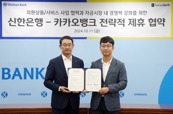 지난 11일 서울시 중구 신한은행 본점에서 진행된 '신한은행-카카오뱅크 전략적 제휴 협약식'에서 신한은행 김광수 고객솔루션 그룹장(왼쪽)과 카카오뱅크 이형주 최고비즈니스책임자(오른쪽)가 기념촬영하는 모습 /사진=신한은행