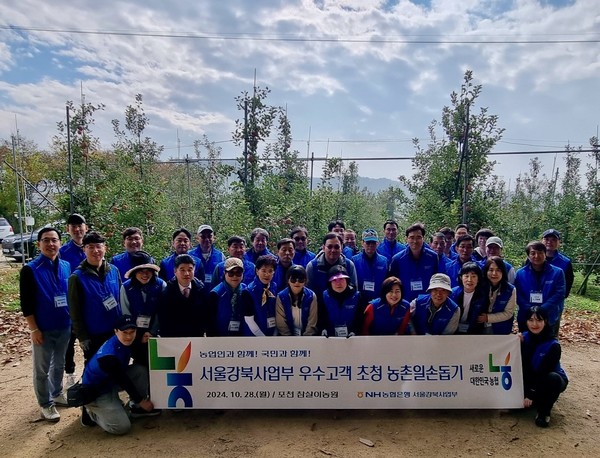 NH농협은행 강승구 서울강북사업본부장(사진 첫째줄 오른쪽에서 세번째)과 지점장 및 우수고객들이 28일 포천시 창수면 소재 사과 농가를 방문해 사과수확 및 일대 자연 정화 활동 등 일손돕기에 구슬땀을 흘렸다. /사진=NH농협은행