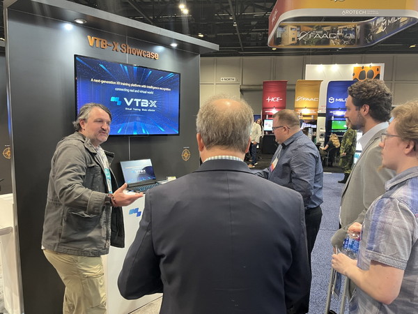 각국의 방산 업체 관계자들이 미국 'I/ITSEC'에서 네비웍스의 가상훈련 소프트웨어 플랫폼 'VTB-X'에 대해 이야기하는 모습. /사진=네비웍스