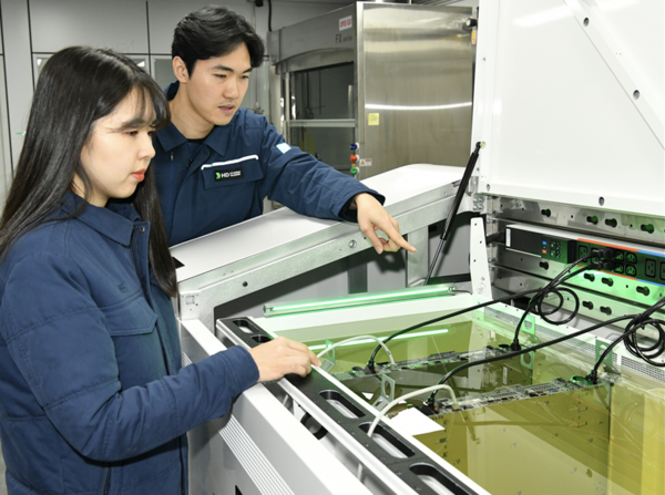 액침냉각설비에 담긴 냉각유와 서버를 테스트하고 있는 HD현대오일뱅크 직원들. /사진=HD현대오일뱅크