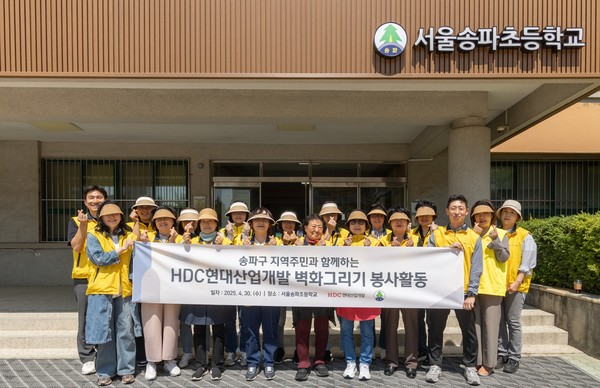 HDC현대산업개발 도시정비 부문 직원과 지역주민 등 20여명이 송파초등학교 담장 벽화 그리기 봉사활동을 진행했다./사진=HDC현대산업개발