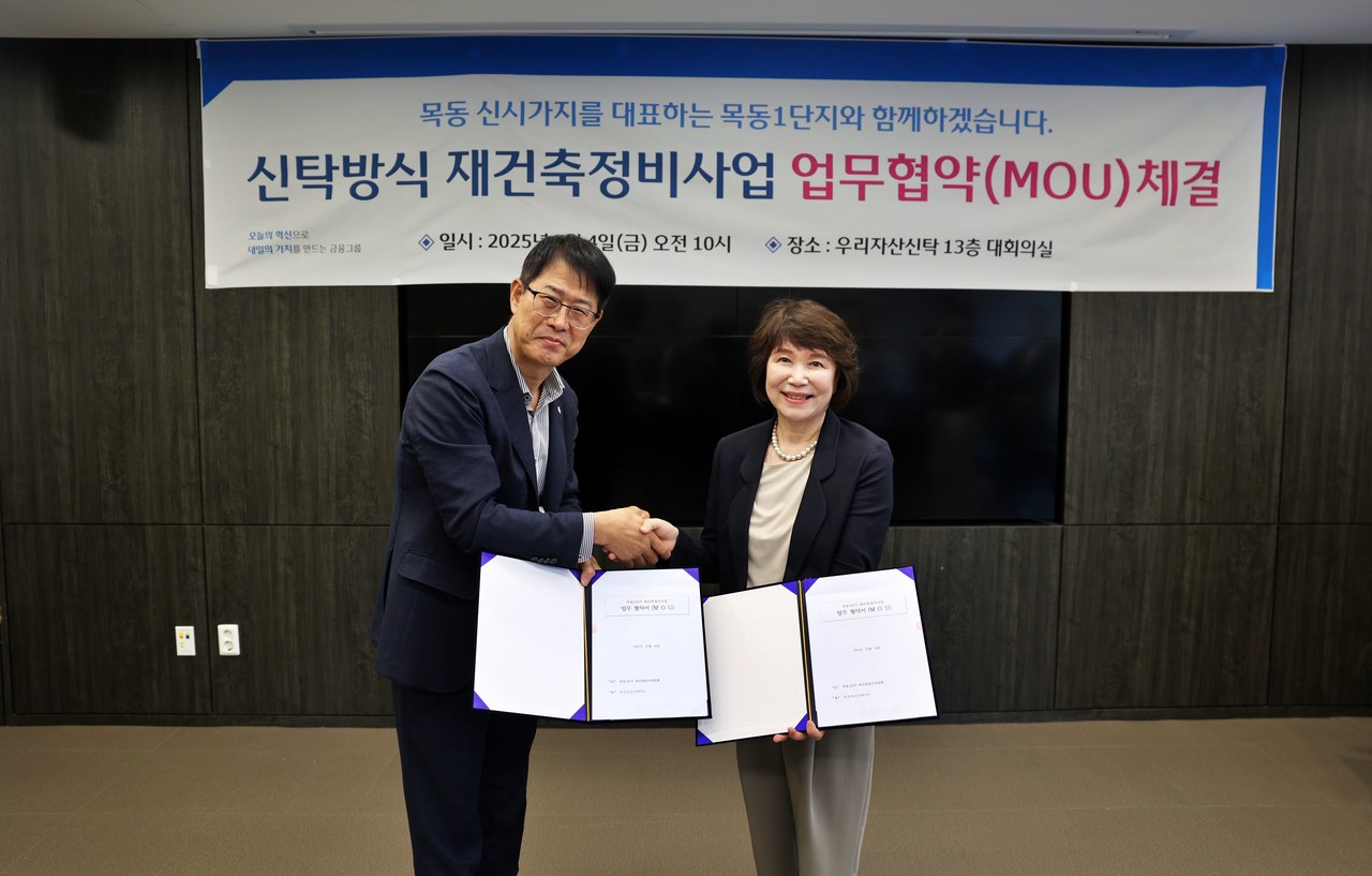 김범석 우리자산신탁 대표(왼쪽)와 정현숙 목동1단지 재건축준비위원장(오른쪽)이 재건축 협력을 다짐하며 악수를 하고있다. / 사진=우리금융그룹