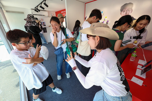 KT가 25일부터 27일까지 3일간 용인 에버랜드 정문 야외 광장에서 고객 체험형 이벤트 'K intelligence LUCKY DROP'를 진행한다. 관람객이 'K LUCKY DROP' 이벤트에 AI와 증강현실 기술이 적용된 콘텐츠를 체험하고 있다. /사진=KT