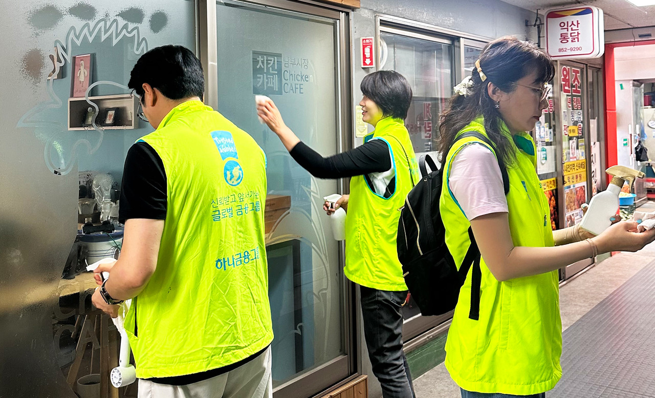 이날 캠페인에 참여한 김덕순 대표이사(사진 가운데)가 임직원들과 남부시장 내 상가 출입구 유리창 청소를 하고 있다. 