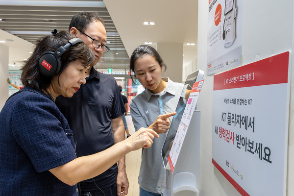 KT플라자에 방문한 고객이 직원으로부터 AI 청력검사 키오스크의 사용법에 대한 설명을 듣고 있다./사진=KT