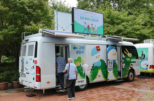 대구 달서구노인종합복지관 어르신들이 '찾아가는 금융교육'에 참여하기 위해 차량형 이동식 점포에 입장하고 있다. / 사진=iM뱅크