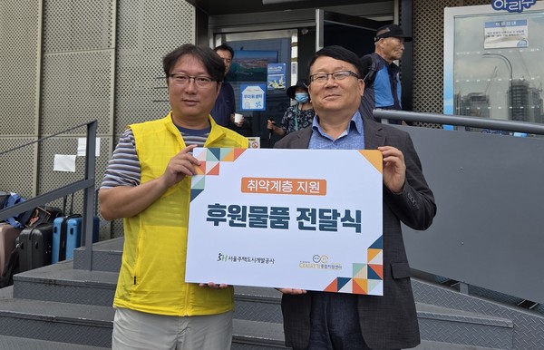 (오른쪽) 민동조 SH 자산운용본부장과 우대경 다시서기센터 팀장이 폭염 대비 물품 전달 후 기념 촬영을 하고 있다./사진=SH