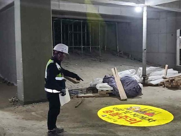 현장근로자가 로고빔 활용 안전표지를 설치하고 확인하고 있는 모습. /사진=LH