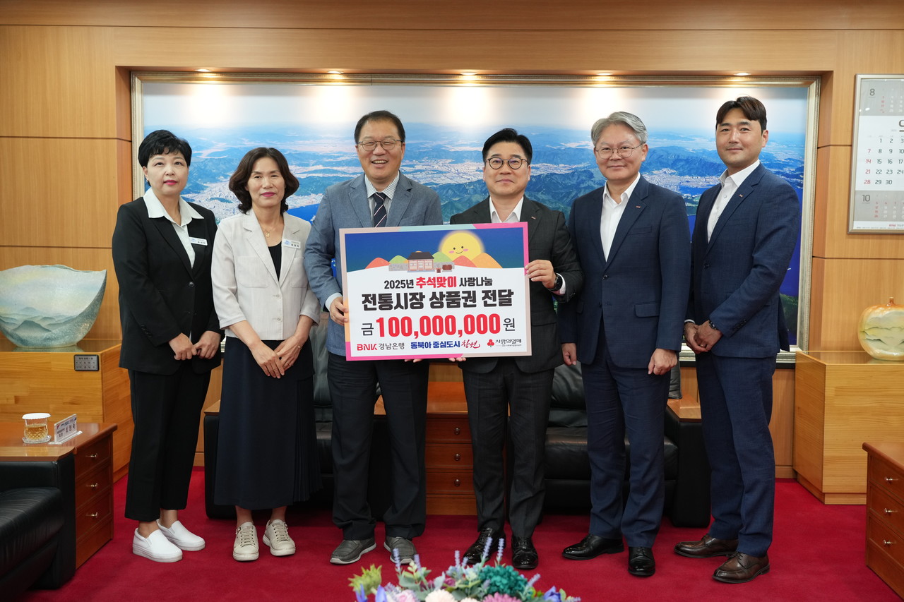 BNK경남은행 허종구 부행장(사진 오른쪽 세번째)이 창원시 장금용 시장권한대행(사진 왼쪽 세번째)에게 ‘전통시장 상품권 기탁 증서’를 전달하고 있다. / 사진=BNK경남은행