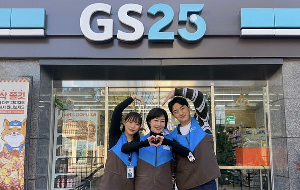 GS25의 OFC(영업관리자)와 가맹 경영주가 매장 앞에서 하트를 그리고 있다. /사진=GS25