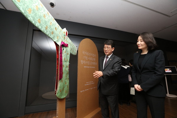 최응천 국가유산청장(왼쪽)과 이홍주 LG생활건강 상무(오른쪽)가 지난 4월 서울 국립고궁박물관에서 열린 '조선 왕실, 대한제국 황실 국가유산 복제 성과 공개 행사'에서 영친왕비가 입었던 소례복(당의).  /사진=LG생활건강